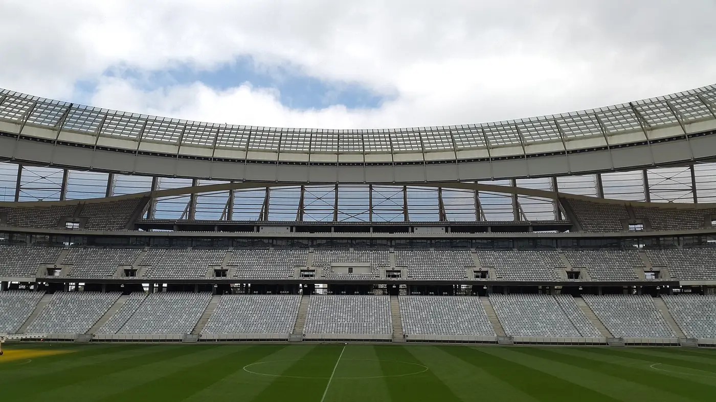 Interior de um recinto desportivo com bancadas e relvado tratado